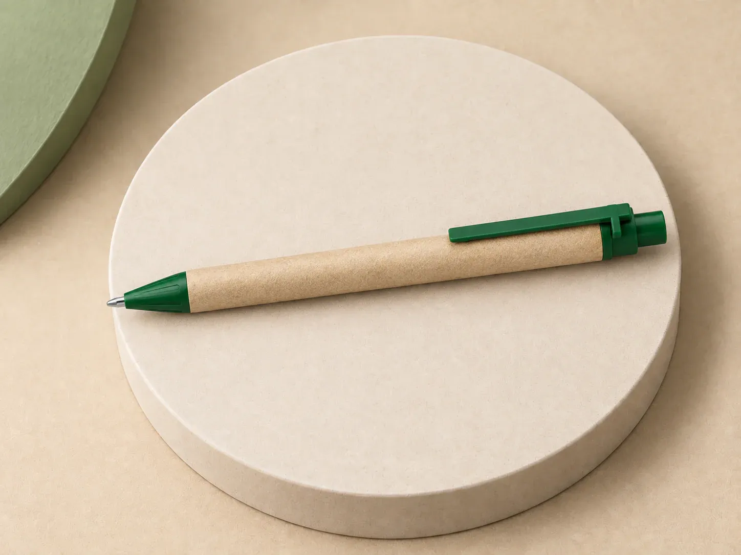 Caneta de papel reciclado, na cor verde, sem personalização: caneta de corpo pardo com ponta, clip reto e botão coloridos