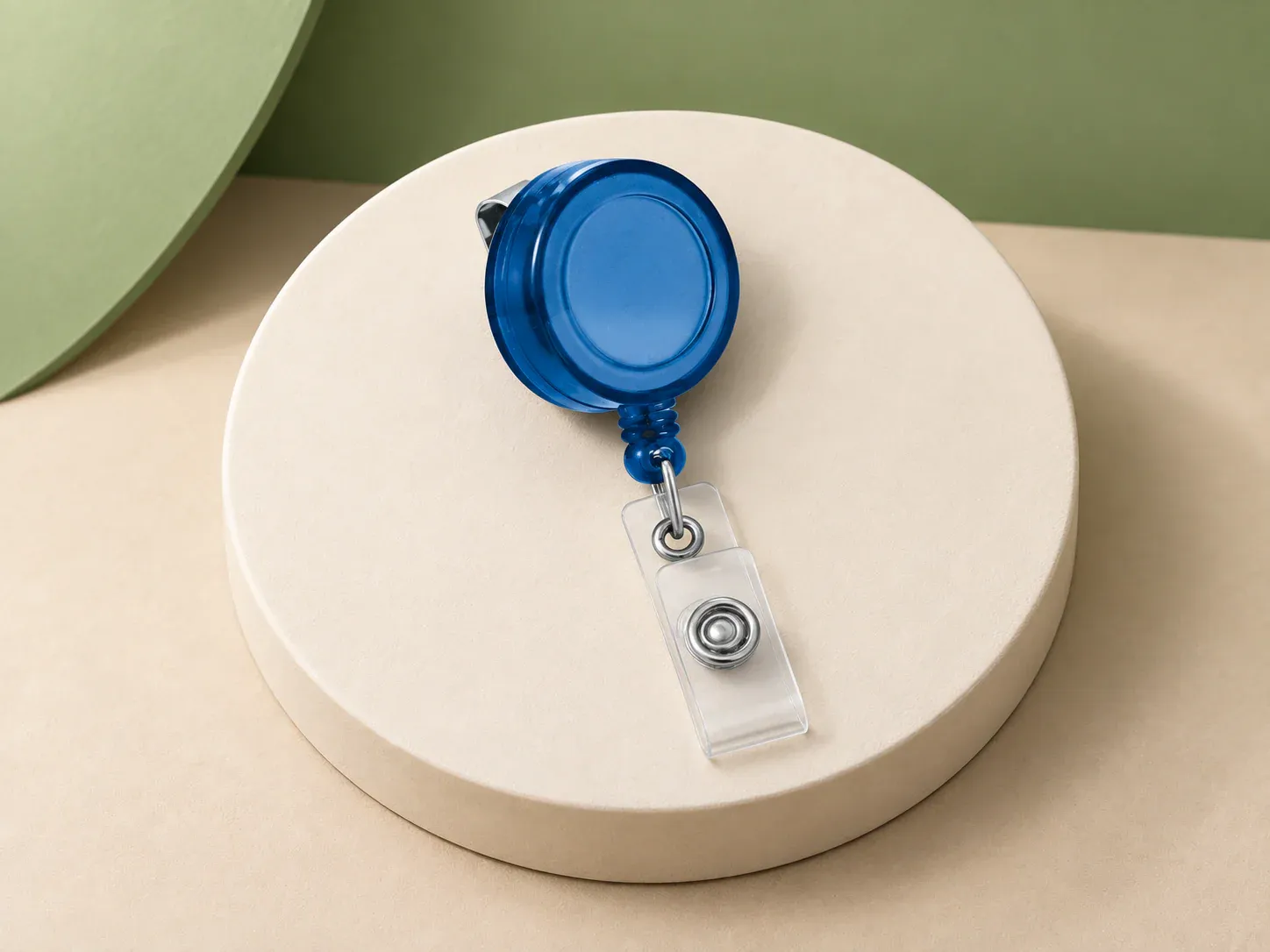 Porta-crachá retrátil, na cor azul, sem personalização: porta-crachá retrátil redondo azul translúcido com clipe traseiro metálico, cordão retrátil e presilha transparente com botão de pressão