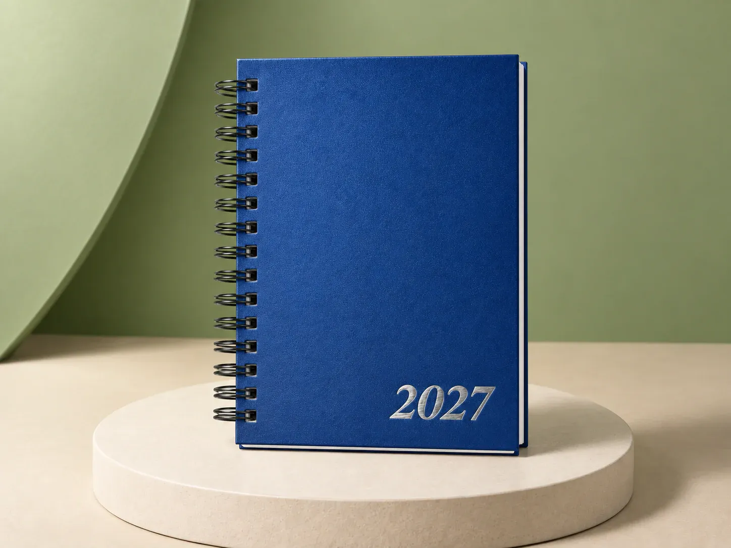 Agenda azul com espiral, na cor azul, sem personalização: agenda de capa azul texturizada com espiral preta lateral e 2027 prateado no canto inferior