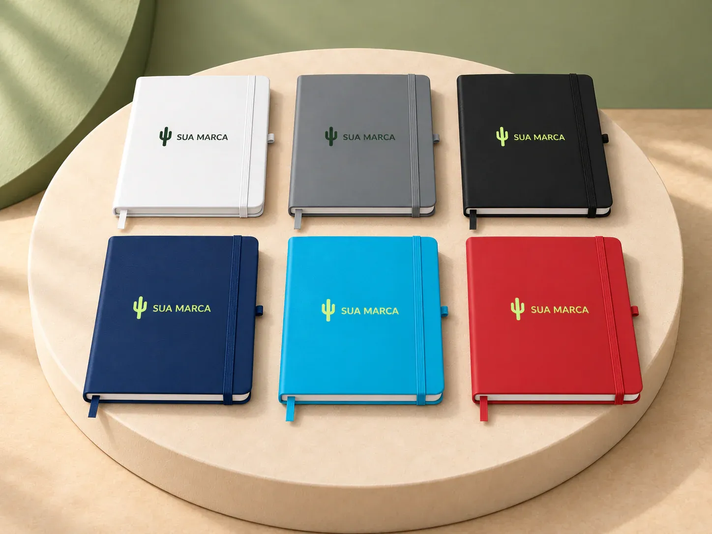 Caderno de anotações A5 com elástico, com exemplo de personalização colorida: um cacto e o texto “SUA MARCA” impressos em cor