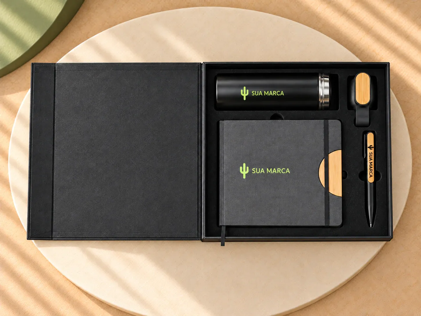 Kit escritório com garrafa térmica, caderno A5 e caneta, com exemplo de personalização colorida: um cacto e o texto “SUA MARCA” impressos em cor