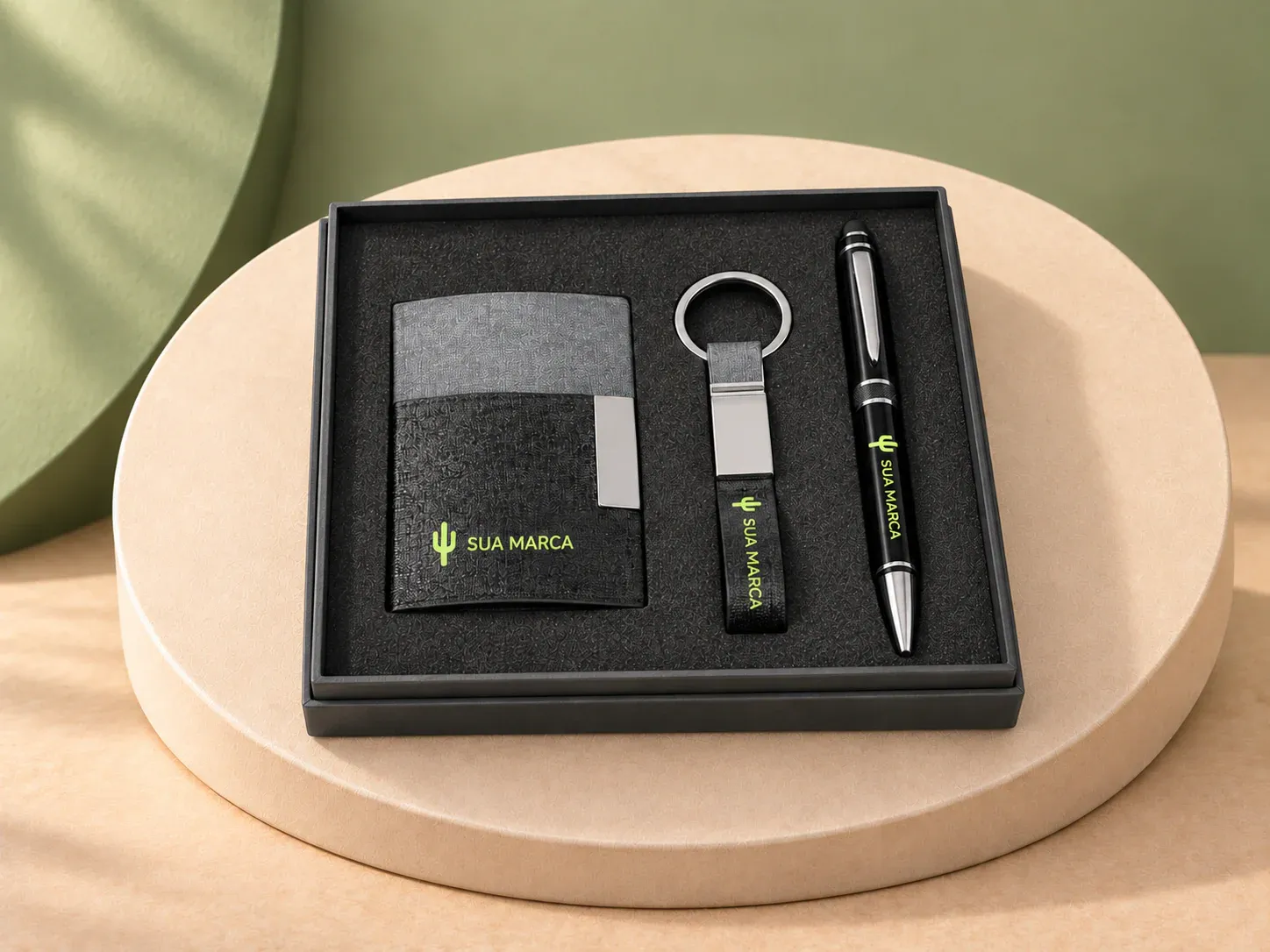 Kit porta cartões, chaveiro e caneta esferográfica, com exemplo de personalização colorida: um cacto e o texto “SUA MARCA” impressos em cor