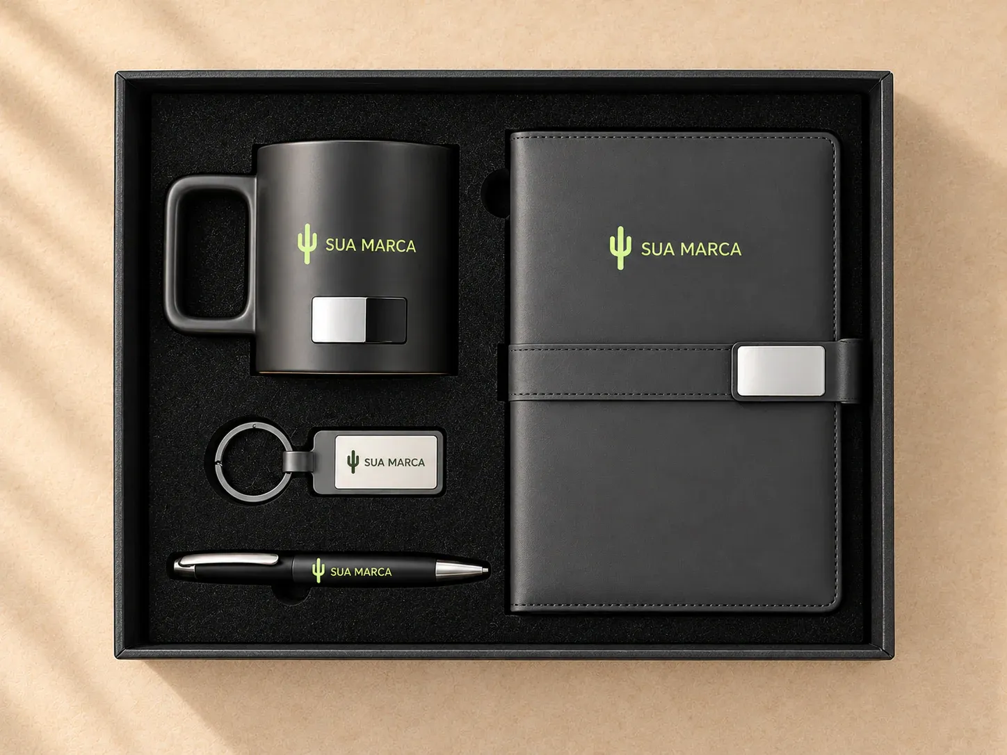 Kit escritório com caderno A5, caneta, caneca e chaveiro, com exemplo de personalização colorida: um cacto e o texto “SUA MARCA” impressos em cor