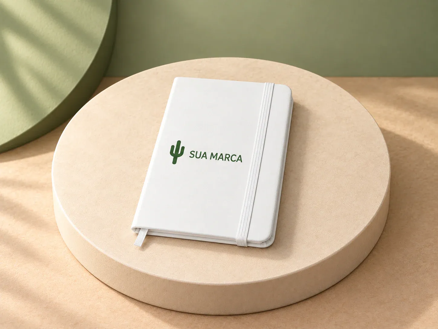 Caderno de bolso em couro sintético com páginas lisas, com exemplo de personalização colorida: um cacto e o texto “SUA MARCA” impressos em cor