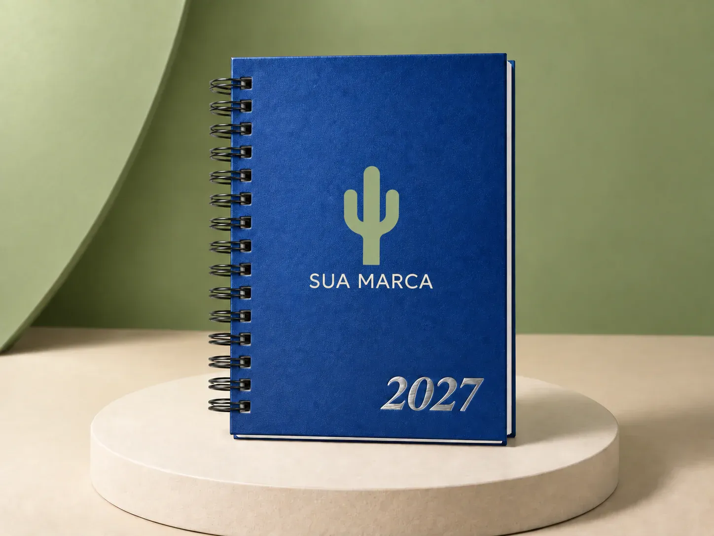 Agenda azul com espiral, com exemplo de personalização colorida: um cacto e o texto “SUA MARCA” impressos em cor