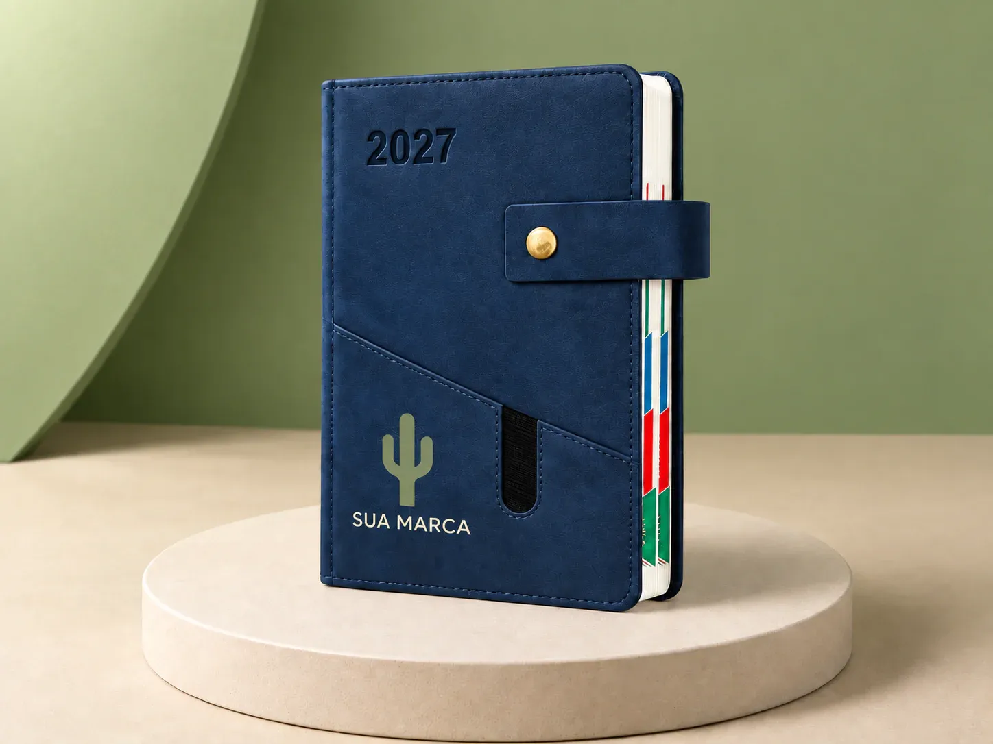 Agenda com fecho de botão e bolso, com exemplo de personalização colorida: um cacto e o texto “SUA MARCA” impressos em cor